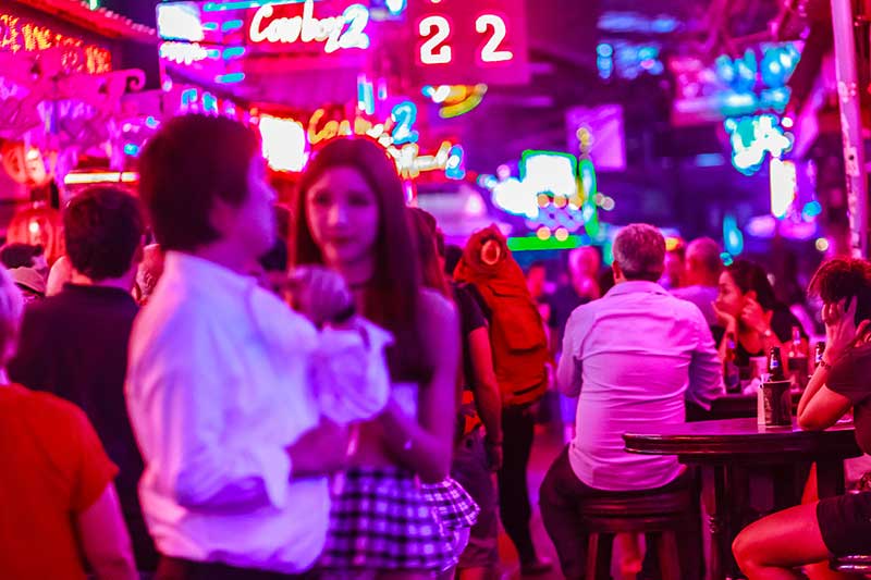 People drinking on a patio in Soi Cowboy party street